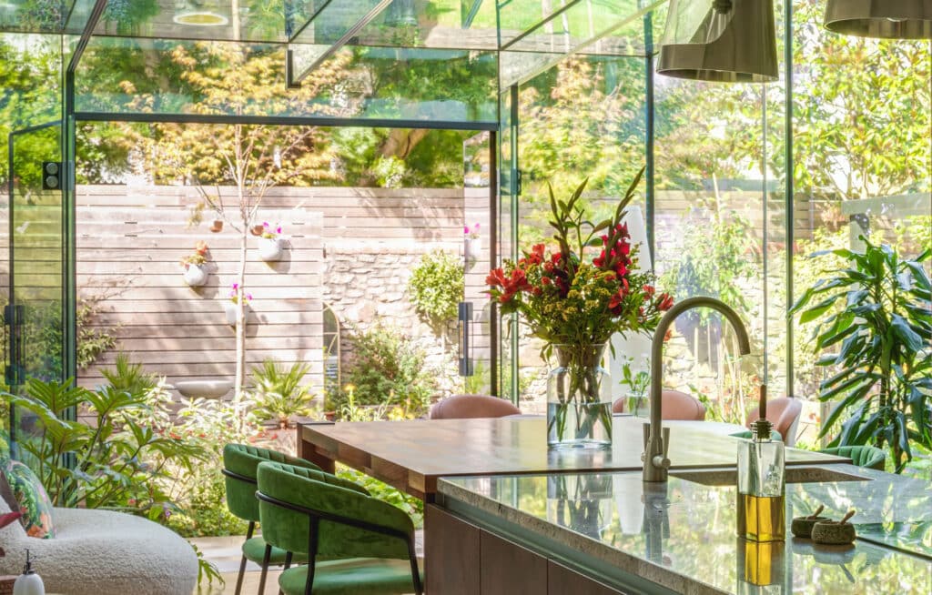 Open-plan kitchen extension with glass doors connecting to a landscaped garden 1