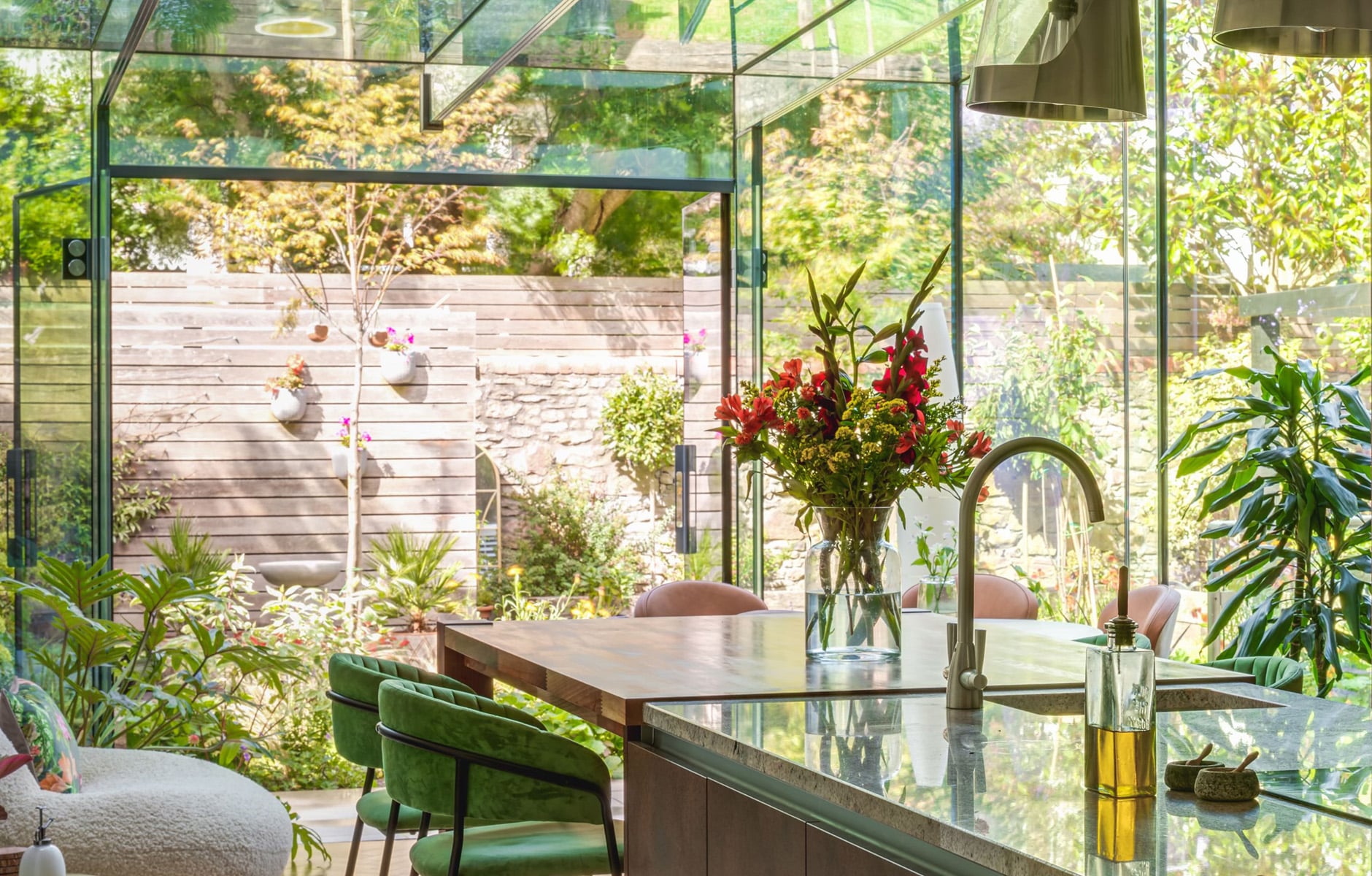 Open-plan kitchen extension with glass doors connecting to a landscaped garden 1