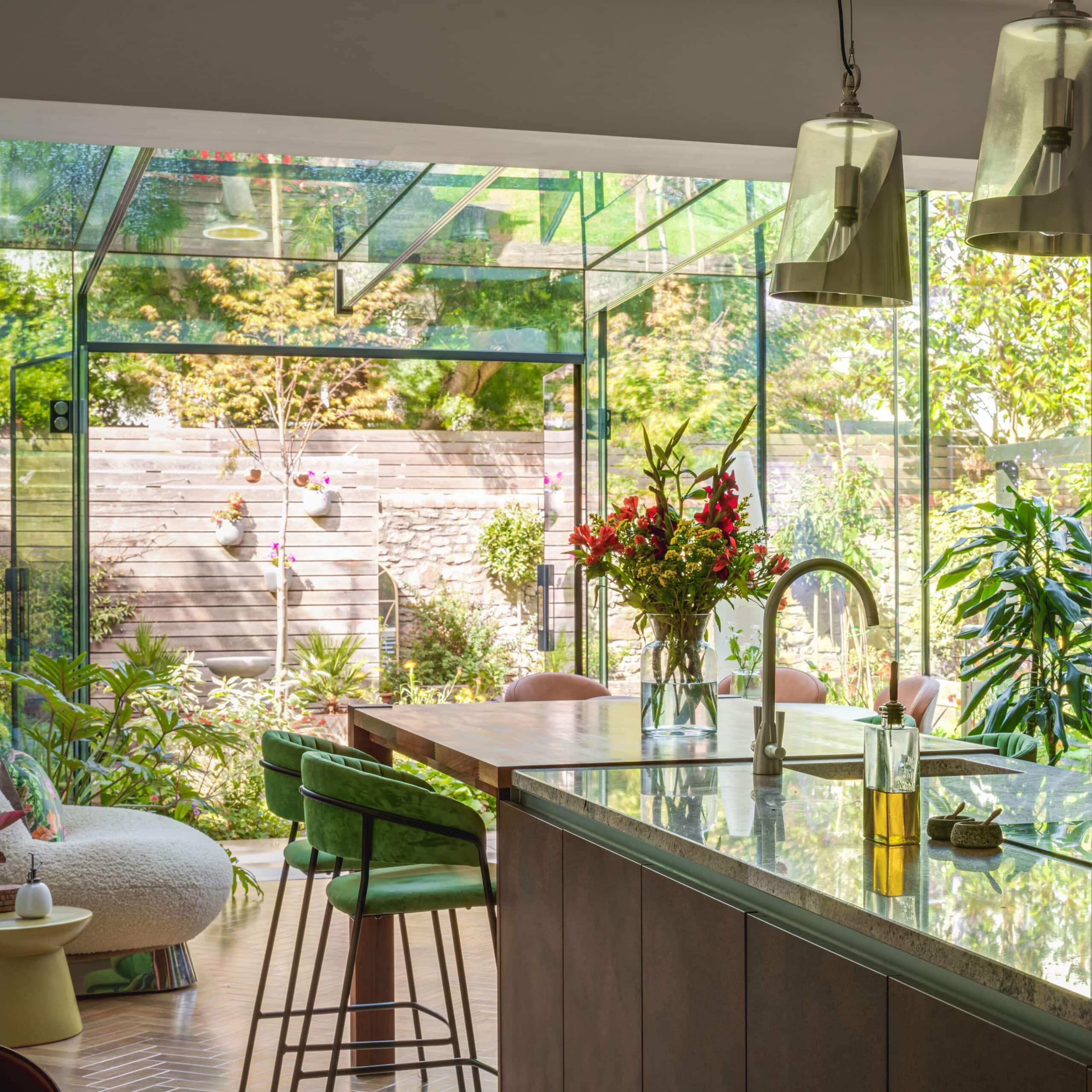 Open-plan kitchen extension with glass doors connecting to a landscaped garden