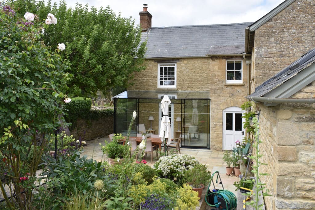 Finished glass extension viewed from garden, showing panoramic glazing and natural views.
