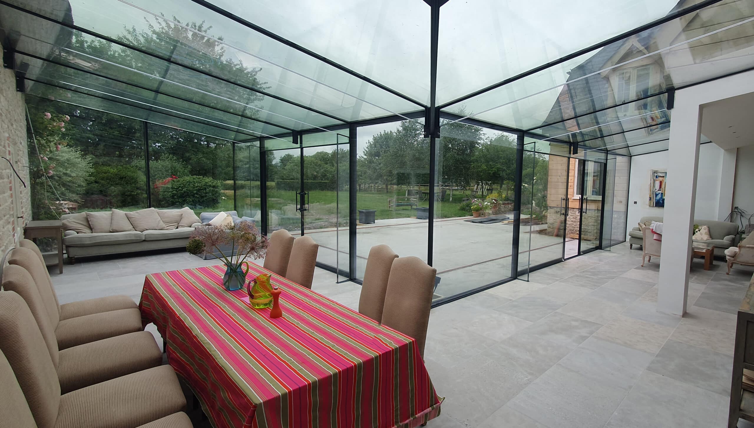Internal view of completed frameless glass extension blending with thatched cottage near Warminster