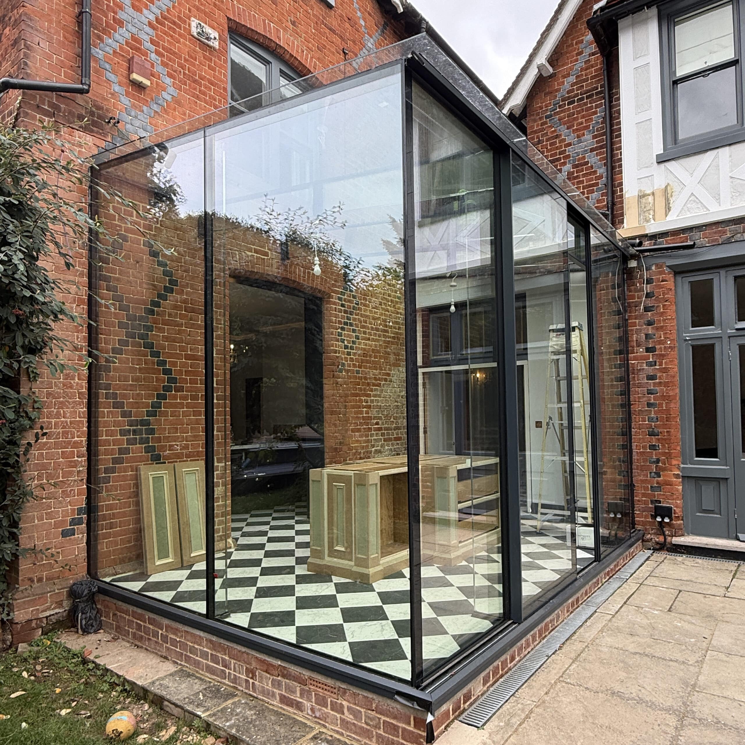 Frameless glass cube offering seamless views and access to the garden.