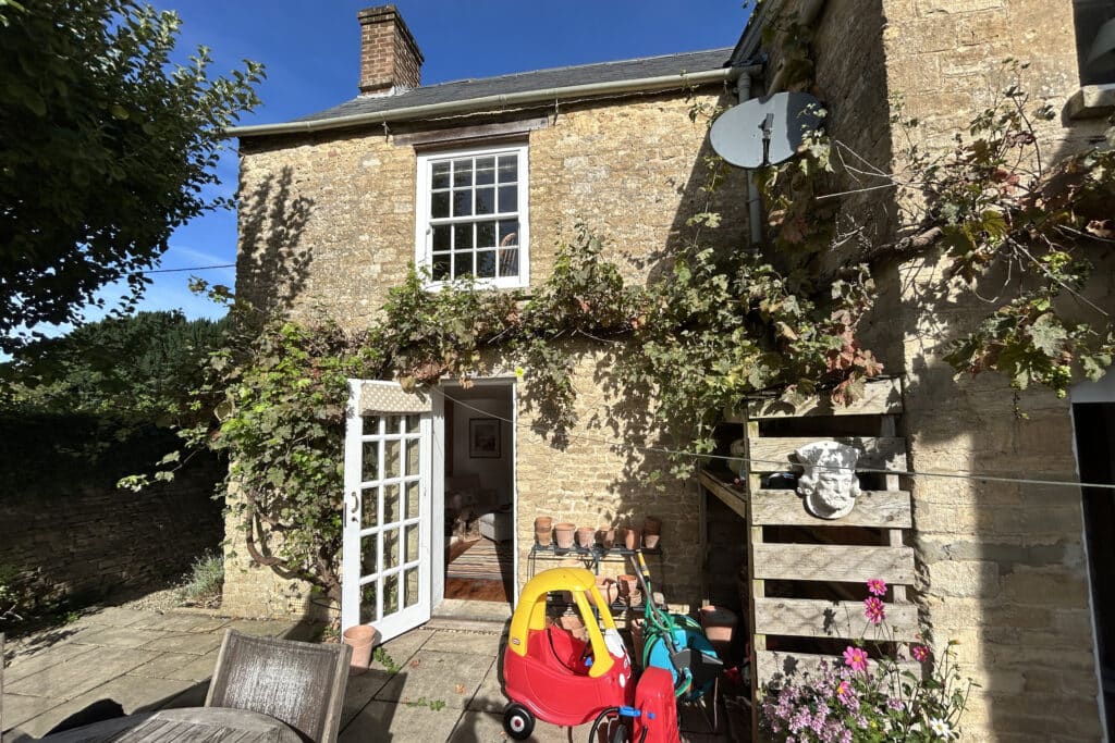 Corner recess of a Cotswold stone cottage before construction of flush-fit glass extension.