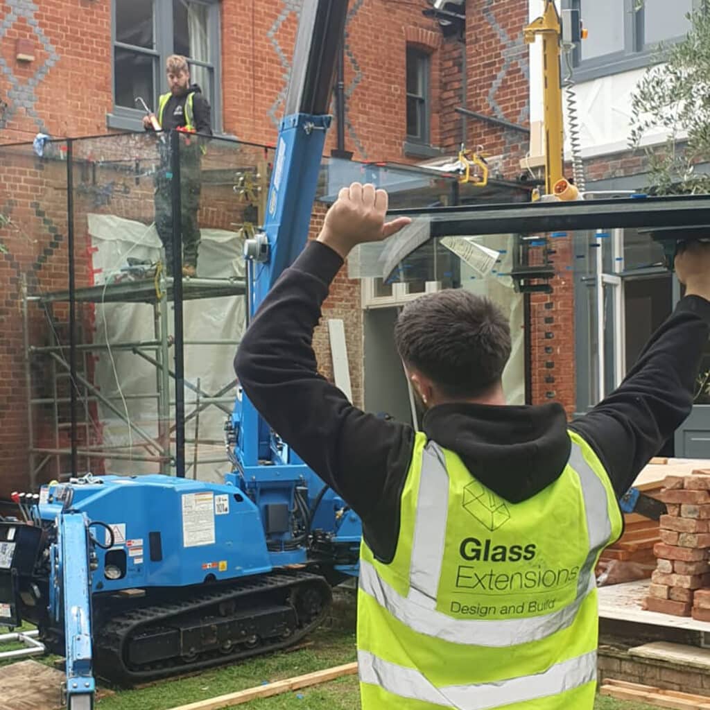 Structural glass roof panel being lifted into position using a crane and specialist lifting equipment.