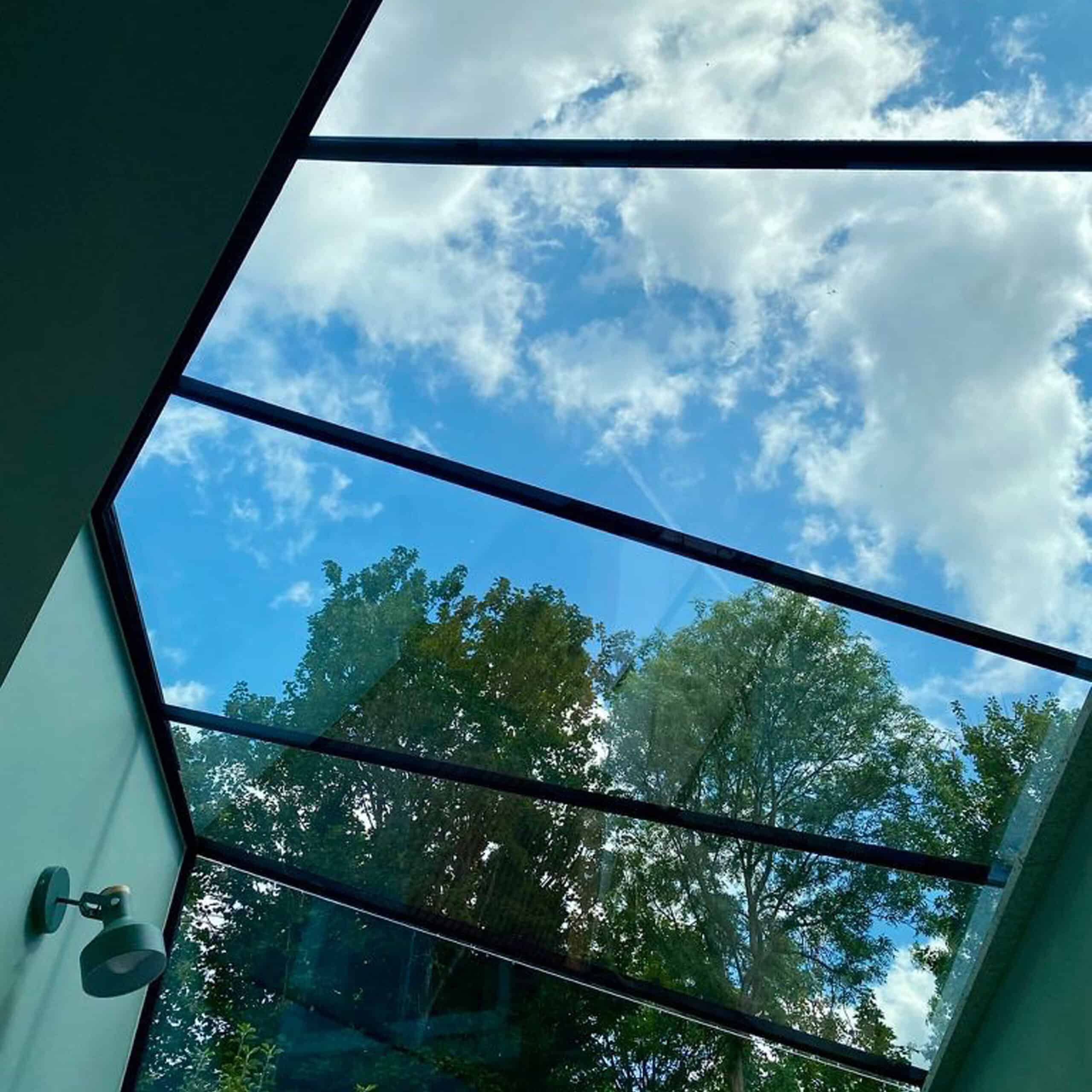 Close internal view of four angled glass roof panels forming a bespoke roof design.