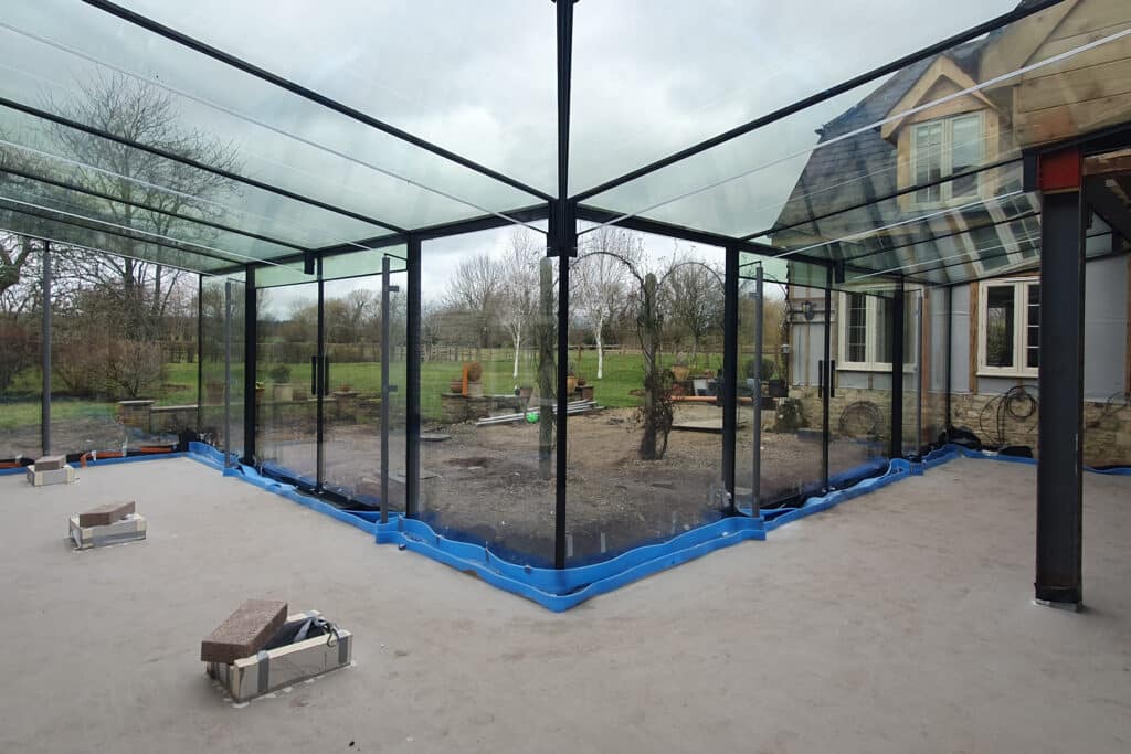 Interior view during installation of frameless glass structure in Warminster extension.