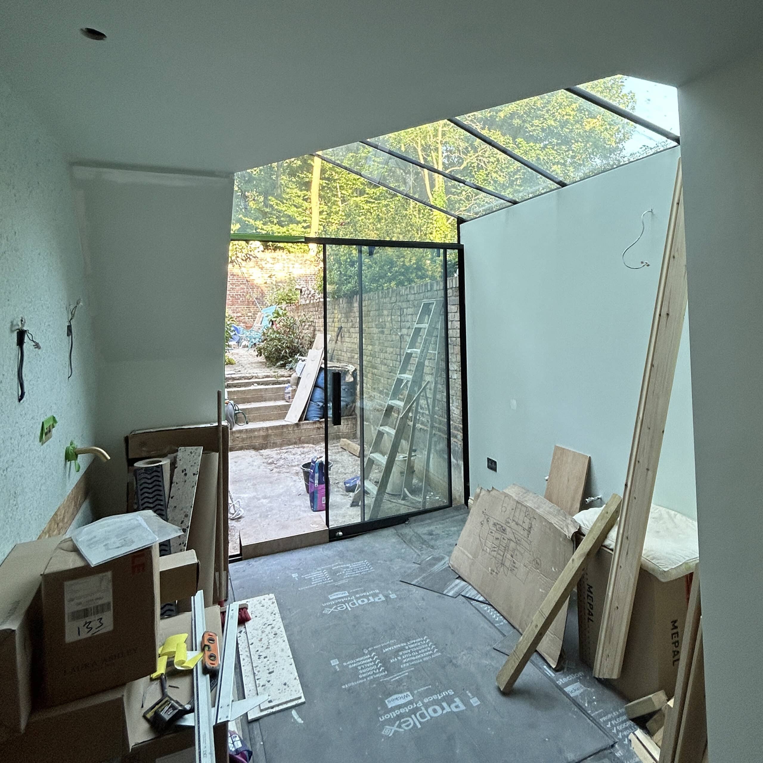 Internal view of London glass extension under construction showing structural framework.